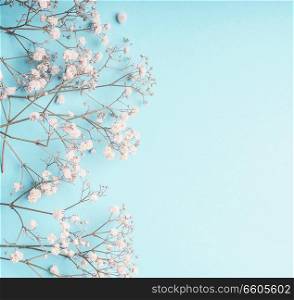 Light blue floral background with white Gypsophila flowers and copy space for your design. Baby&rsquo;s-breath flowers on pastel blue desktop. Flat lay spring and summer
