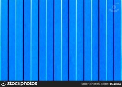 Light blue metallic fence made of corrugated steel sheet with vertical guides.. Corrugated Light blue iron sheet background close up.