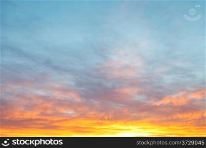 light blue morning sky over pastel pink and yellow sunrise clouds in autumn