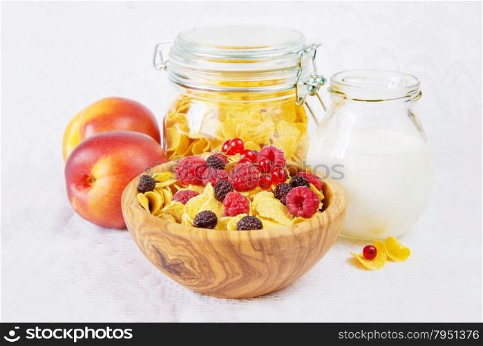 Light breakfast consisting of cornflakes with different berries and milk