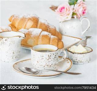 Light breakfast with a cup of coffee, croissants, cream and butter