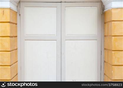 Light brown wooden door in the building. Old wooden doors with classic style building.