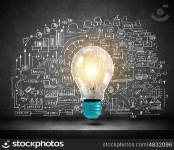 Light bulb and drawing business strategy at background. Ideas for your business