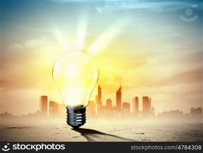 Light bulb and nature. Image of light bulb against city background. Ecological concept