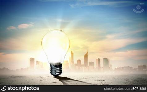Light bulb and nature. Image of light bulb against city background. Ecological concept