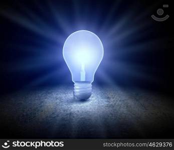 Light bulb. Background image with glowing light bulb on cement surface