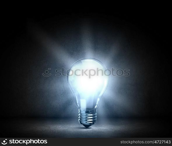 Light bulb. Background image with glowing light bulb on cement surface