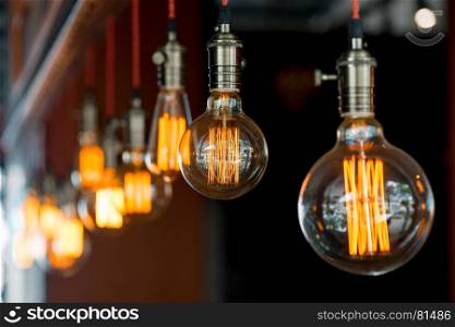 light bulb hanging from the ceiling in a retro style closeup in darkness