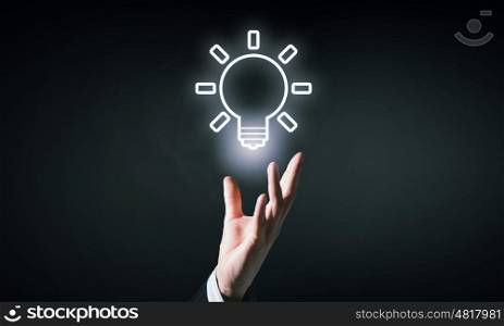 Light bulb icon. Hand of businessman holding drawn light bulb icon