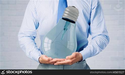 Light bulb in hand. Close up of businessman holding in hands glowing light bulb