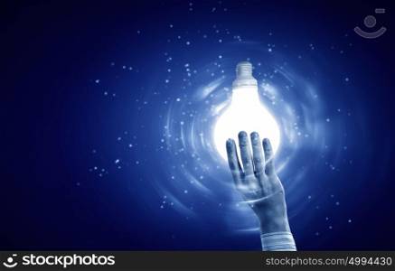 Light bulb in hand. Close up of human hand holding light bulb sign in palm