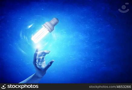 Light bulb in hand. Close up of human hand touching with finger light bulb