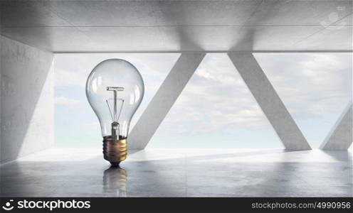 Light bulb in modern office. Glass light bulb against office room with large window