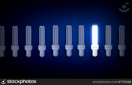 Light bulb. Light bulbs on dark background with one burning