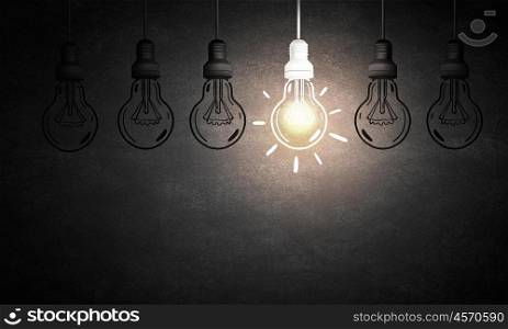 Light bulb. Light bulbs on dark background with one glowing