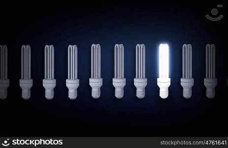 Light bulb. Light bulbs on dark background with one glowing