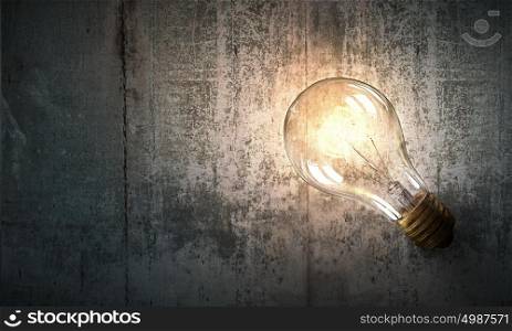 Light bulb on wooden surface. Power and energy concept with light bulb on wooden surface