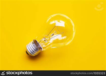 Light bulb on yellow background. Top view