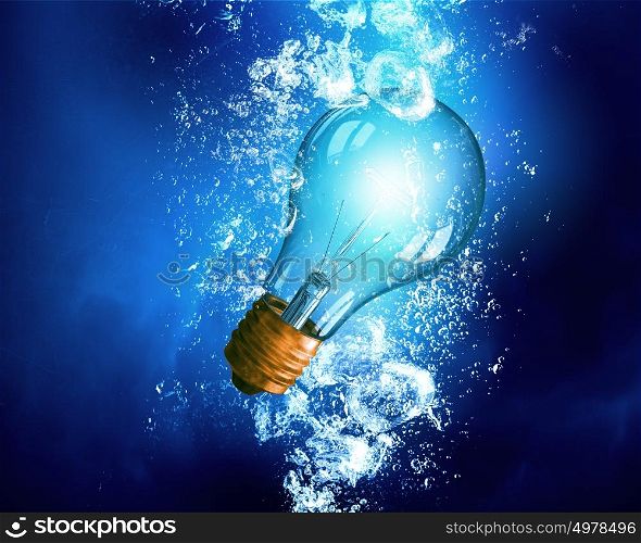 Light bulb under water. Energy concept with light bulb under clear blue water