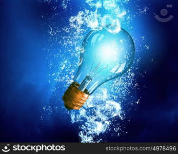 Light bulb under water. Energy concept with light bulb under clear blue water