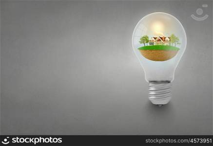 Light bulb with concept of ecological construction in it. Green light bulb