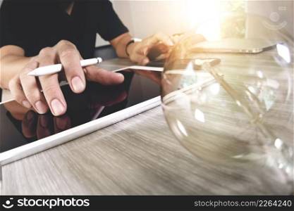 light bulb with designer hand working with laptop computer and creative business strategy as concept