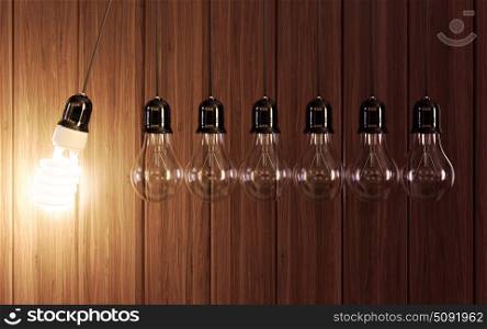 Light bulbs in perpetual motion with glowing energy saving one.
