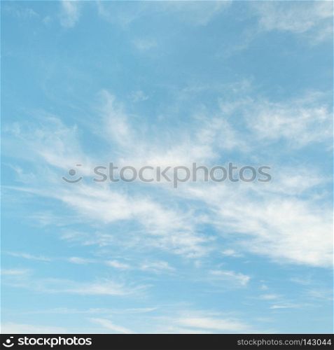 Light cirrus clouds on blue sky background.