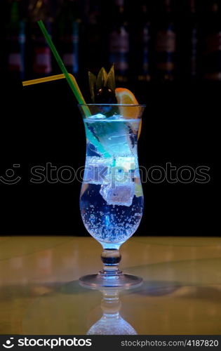 Light cocktail with orange and pineapple with soda at dark background