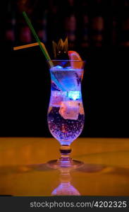 Light cocktail with orange and pineapple with soda at dark background