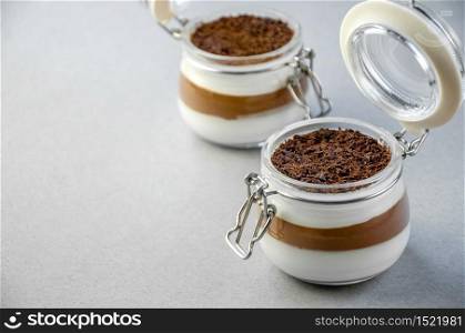Light Creamy Vanilla and Chocolate Mousse Dessert in a Glass Jar On a Gray Background. Concept Valentine&rsquo;s Day.. Light Creamy Vanilla and Chocolate Mousse Dessert in a Glass Jar On a Gray Background. Concept Valentine&rsquo;s Day