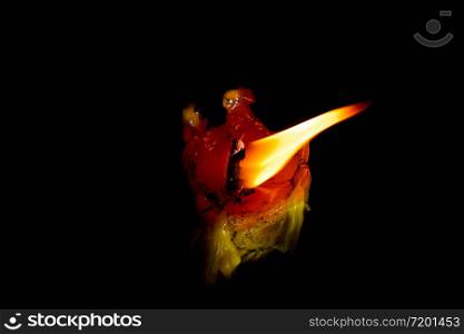 Light flame candle burning brightly on black background