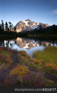 Light hits Mt Shuksan well at sunset above picture lake