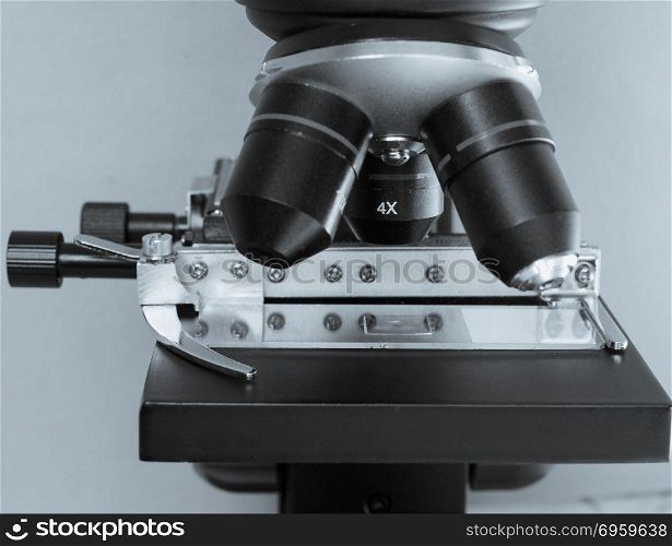 Light microscope detail. Detail of optical microscope lens and cross table with slide - selective focus