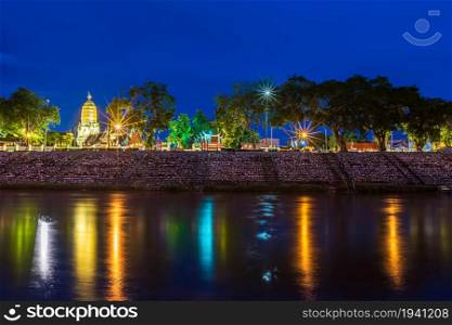 light on the Nan River and Chedi of Prang Wat Phra Si Rattana Mahathat also colloquially at the Nan River and the park at night in Phitsanulok, Thailand.
