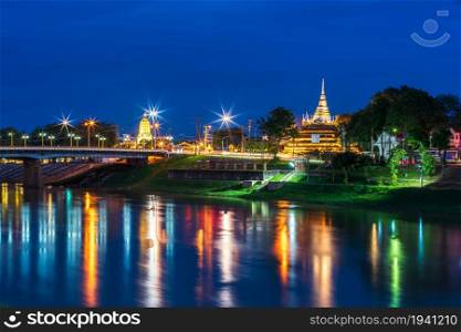 light on the Nan River on the Naresuan Bridge and Chedi of Wat Ratchaburana and Prang Wat Phra Si Rattana Mahathat also colloquially at the Nan River and the park at night in Phitsanulok, Thailand.
