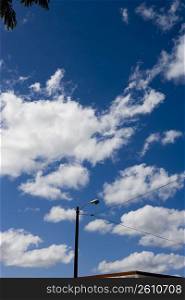 Light post with clouded sky background