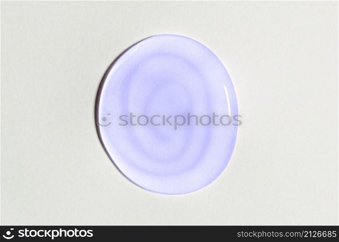 Light purple or violet transparent oval gel drop isolated on white background. Top view. Virus protection or cosmetics concept. Face Serum texture Trendy banner with 2022 color of the year very peri.. Light purple or violet transparent oval gel drop isolated on white background. Top view. Virus protection or cosmetics concept. Face Serum texture Trendy banner with 2022 color of the year very peri