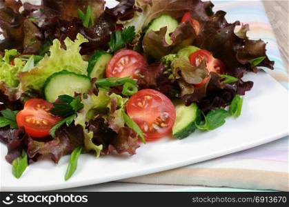 Light salad from lettuce leaves with tomatoes and cucumber