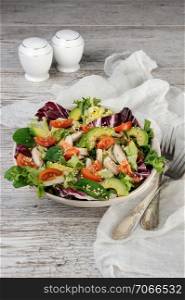 Light salad organic mix lettuce with tomatoes, avocado, slices of chicken breast, seasoned roasted sesame seeds.