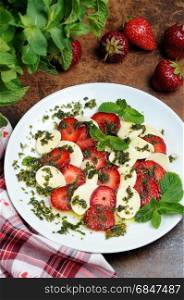 Light snack caprese with strawberries and mozzarella dressed mint pesto. Strawberry caprese with mozzarella