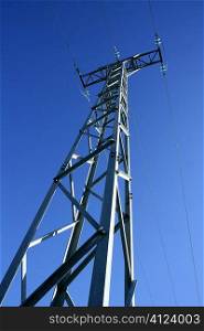 Light steel electricity tower pole over vibrant blue summer sky