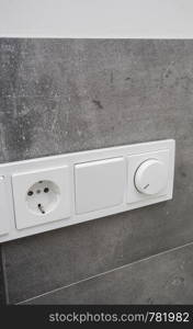 Light switch on the gray textured wall, light switch concrete wall close-up. Light switch on the gray textured wall, light switch concrete wall