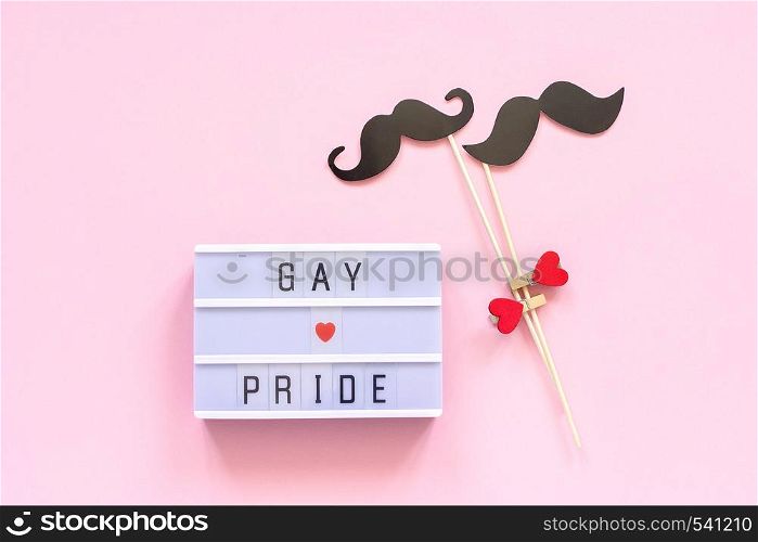 Lightbox text Gay pride and couple paper mustache props on pink background. Concept Homosexuality gay love National Day Against Homophobia or International Gay Day Top view Greeting card.. Lightbox text Gay pride and couple paper mustache props on pink background. Concept Homosexuality gay love National Day Against Homophobia or International Gay Day Top view Greeting card