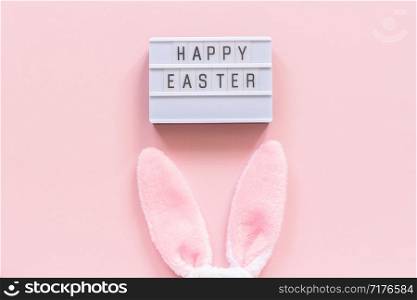Lightbox text Happy Easter and bunny ears on pink paper background. Concept Easter minimal style Creative top-down composition Flat lay Greeting card.. Lightbox text Happy Easter and bunny ears on pink paper background. Concept Easter minimal style Creative top-down composition Flat lay Greeting card