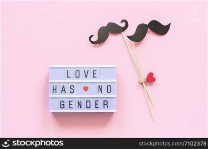 Lightbox text Love has no gender and couple paper mustache props on pink background. Concept Homosexuality gay love National Day Against Homophobia or International Gay Day Top view Greeting card.. Lightbox text Love has no gender and couple paper mustache props on pink background. Concept Homosexuality gay love National Day Against Homophobia or International Gay Day Top view Greeting card