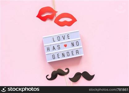Lightbox text Love has no gender, couple paper mustache lips props on pink background. Concept Homosexuality gay love National Day Against Homophobia or International Gay Day Top view Greeting card.. Lightbox text Love has no gender, couple paper mustache lips props on pink background. Concept Homosexuality gay love National Day Against Homophobia or International Gay Day Top view Greeting card