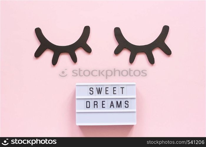 Lightbox text Sweet dreams and decorative wooden black eyelashes, closed eyes on pink paper background. Concept Good night Greeting card Top view Creative flat lay.. Lightbox text Sweet dreams and decorative wooden black eyelashes, closed eyes on pink paper background. Concept Good night Greeting card Top view Creative flat lay
