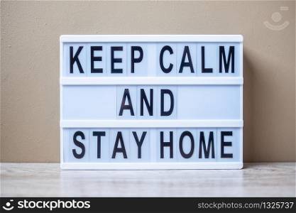 lightbox with text KEEP CALM AND STAY HOME on table. Coronavirus, Covid-19, Quarantines and Social Distancing concept