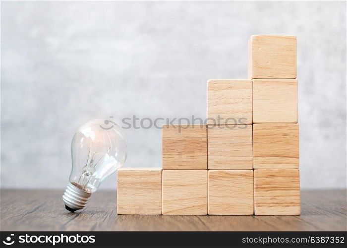 Lightbulb and wood block stack of building with business idea, creative, thinking goal, strategy and innovation concept
